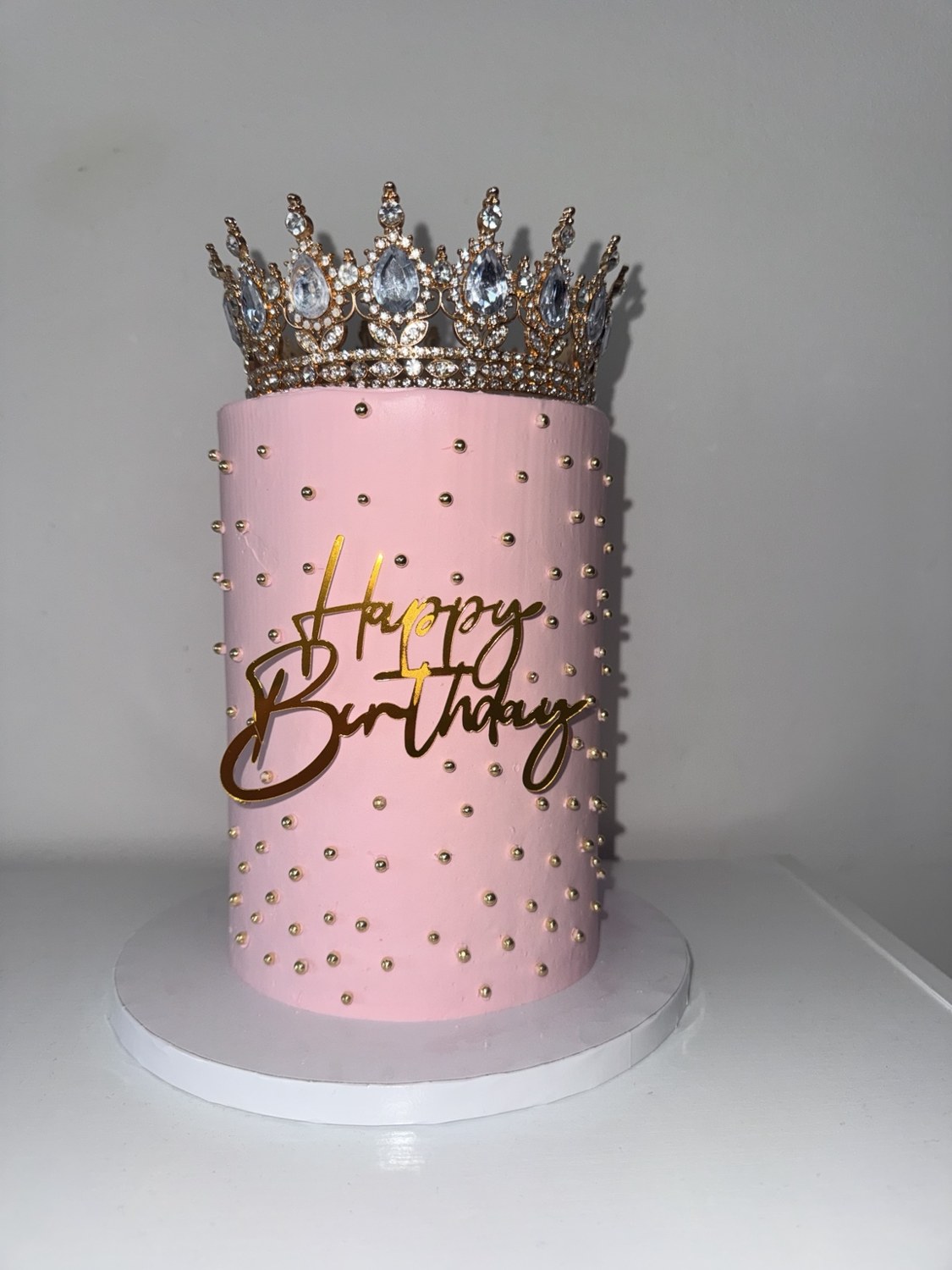 Gâteau rose avec perles dorées et couronne